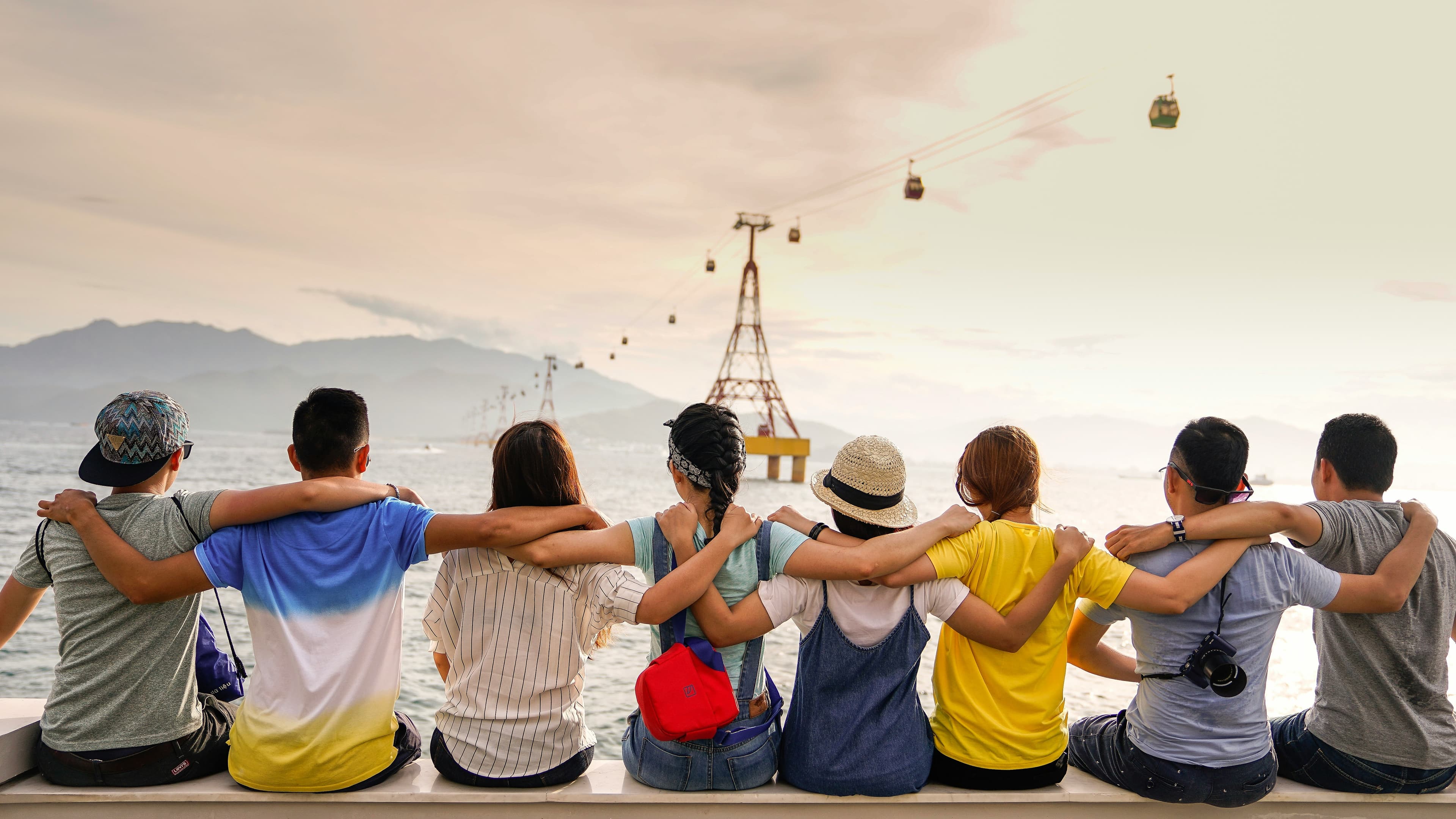 Groupe d'amis enlacés face au coucher de soleil